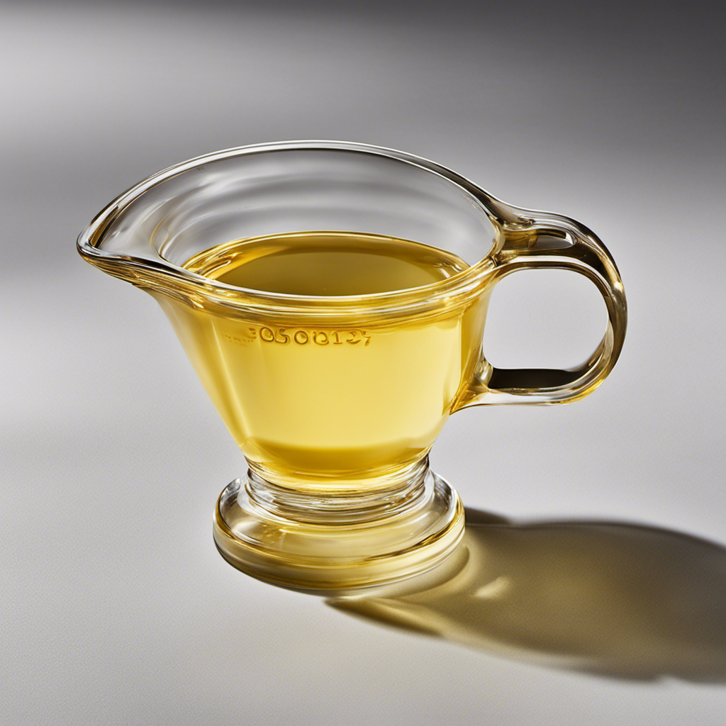 An image showcasing a clear glass measuring cup filled with melted butter up to the 2 tablespoons mark