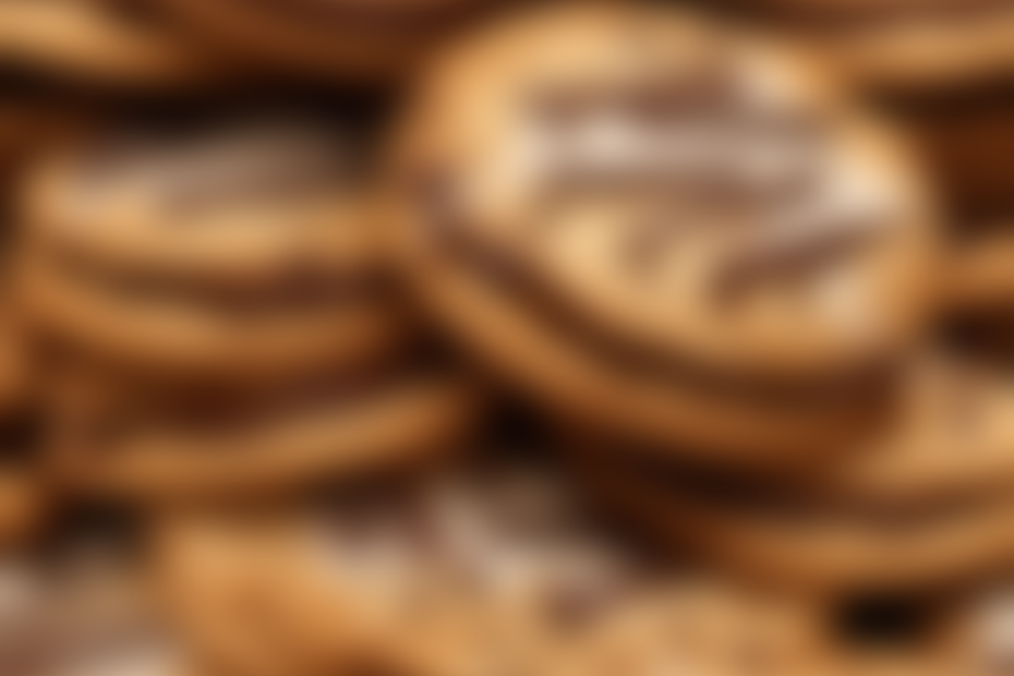 An image featuring a stack of freshly baked, golden-brown cookies generously slathered with creamy cookie butter, oozing out from between each perfectly crumbly layer